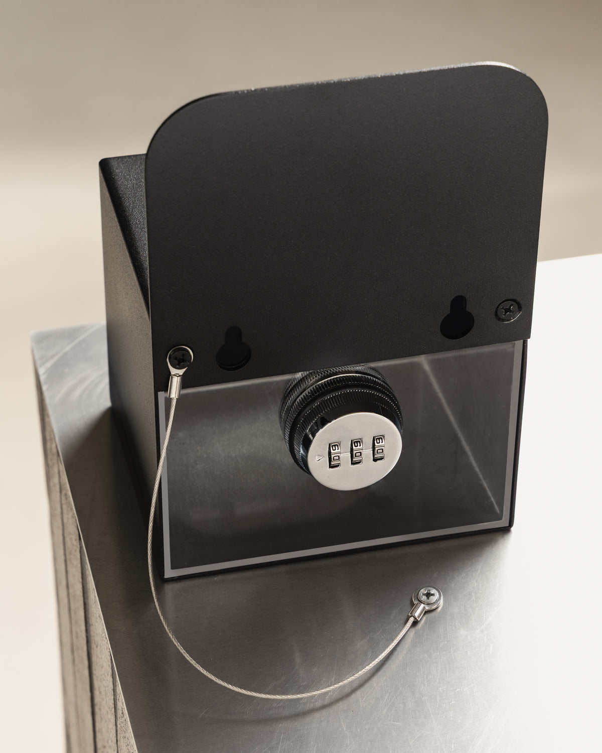 Rear view of the black FOLD Tip Box showing the combination lock, security chain and keyhole fixings