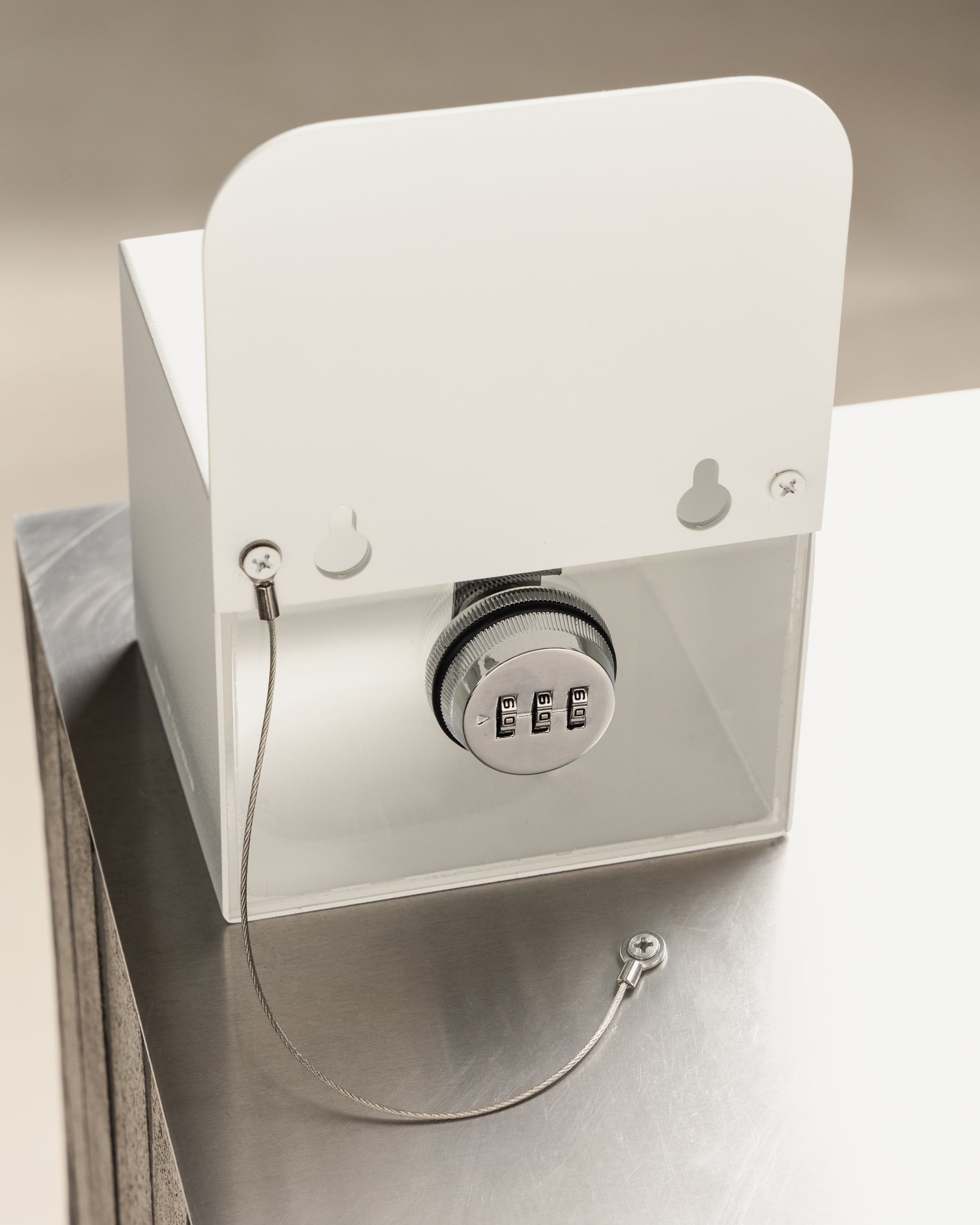 Rear view of the white FOLD Tip Box showing the combination lock, security chain and keyhole fixings